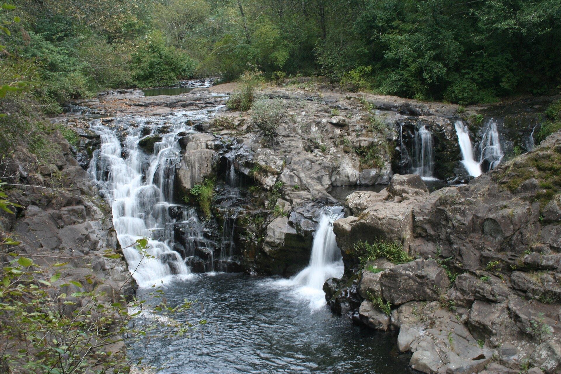 Multiple small waterfall drops flowing over dark rock at Moulton Falls